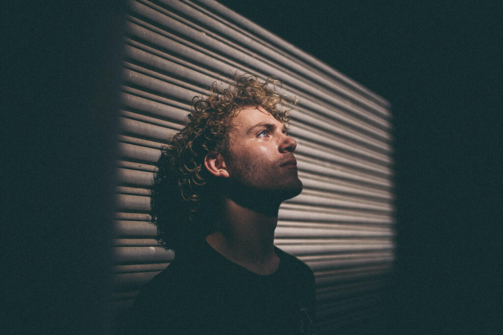 Man leaning head on wall